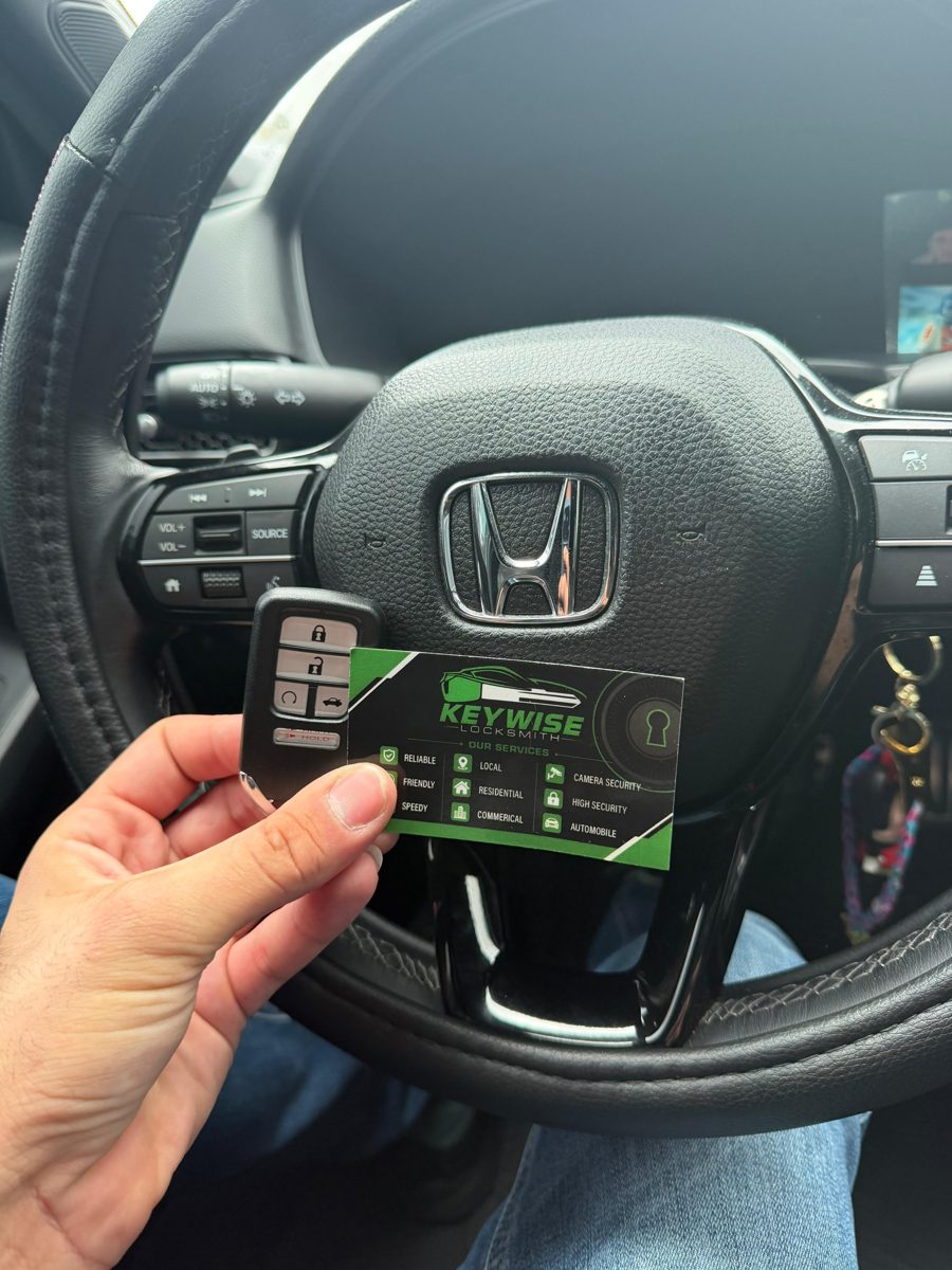 Keywise Locksmith technician holding a newly programmed Honda smart key fob inside the vehicle in Orange County, CA