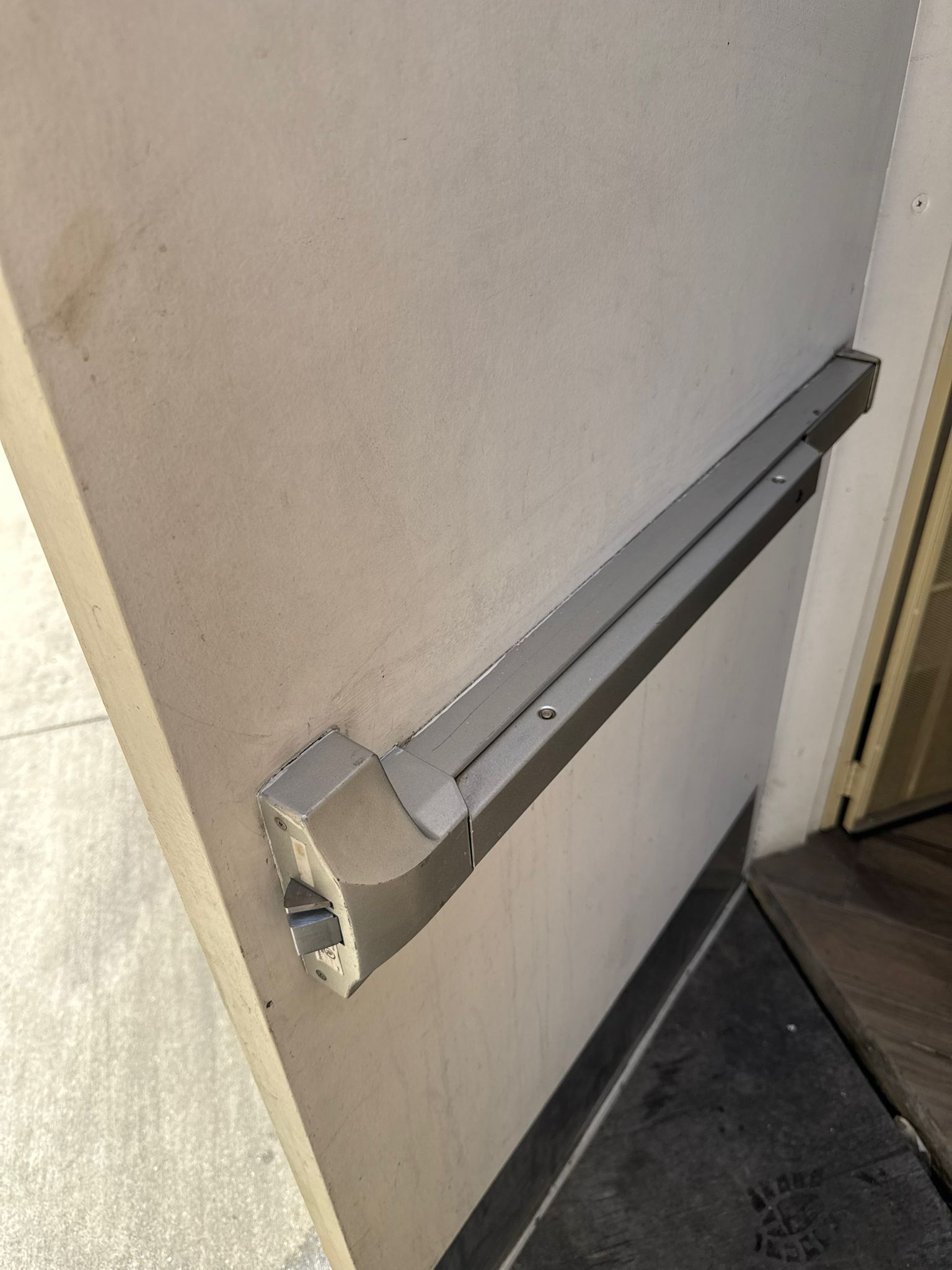 Keywise Locksmith Kwikset deadbolt rekeyed on a black front door beside a knee scooter in Orange County, CA